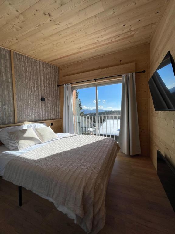 a bedroom with a bed and a large window at Chalet Isard Pyrénées 2000 - 300m des pistes in Bolquere Pyrenees 2000