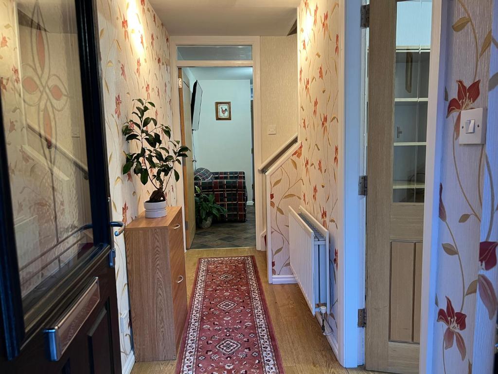 a hallway with a door and a rug on the floor at 3 Bedroom House near city centre in Belfast
