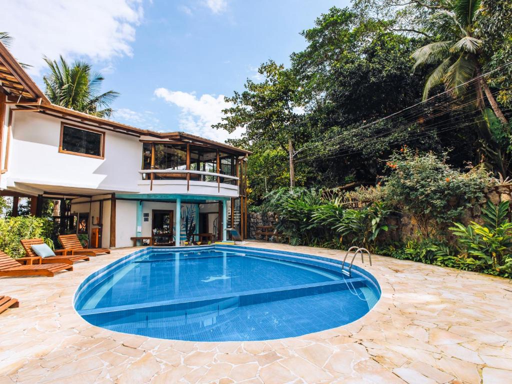 uma imagem de uma piscina em frente a uma casa em VELINN Hotel Santa Tereza em Ilhabela