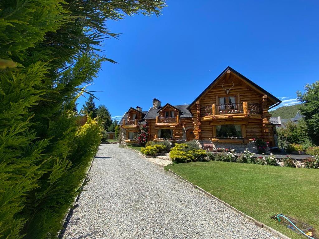 uma casa de log com um caminho que conduz a ela em Las Baitas em San Carlos de Bariloche