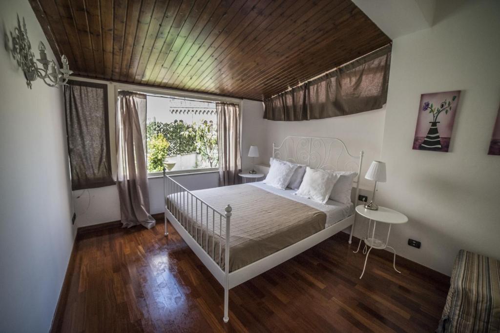 タオルミーナにあるLa Maison Jardin Apartmentの木製の天井のベッドルーム1室(白いベッド1台付)
