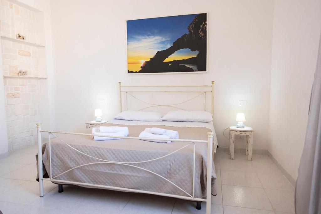 ein Schlafzimmer mit einem Bett und einem Wandgemälde in der Unterkunft CALA ROTONDA Appartamento in centro in Favignana