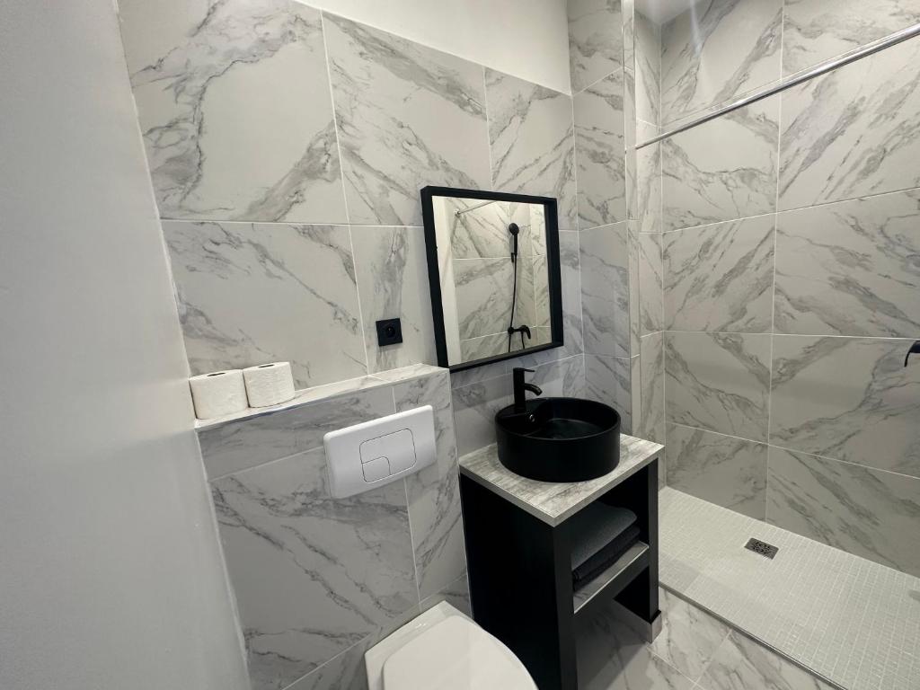 a white bathroom with a toilet and a sink at La maison de Giulia Menton in Menton