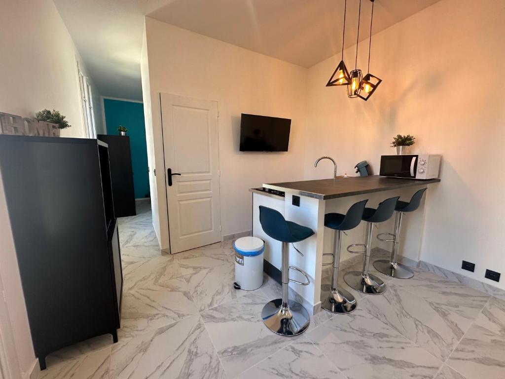 a kitchen with a counter and a bar with stools at La maison de Giulia Menton in Menton
