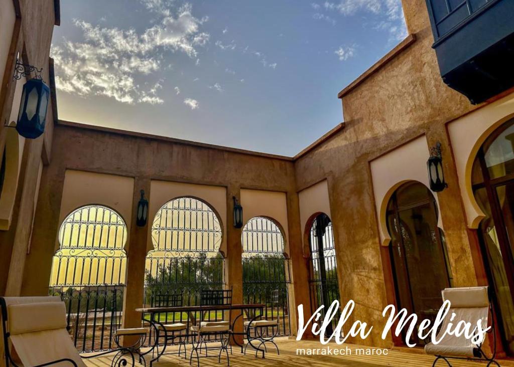 un patio con sedie e tavoli in un edificio di Villa Melias a Marrakech
