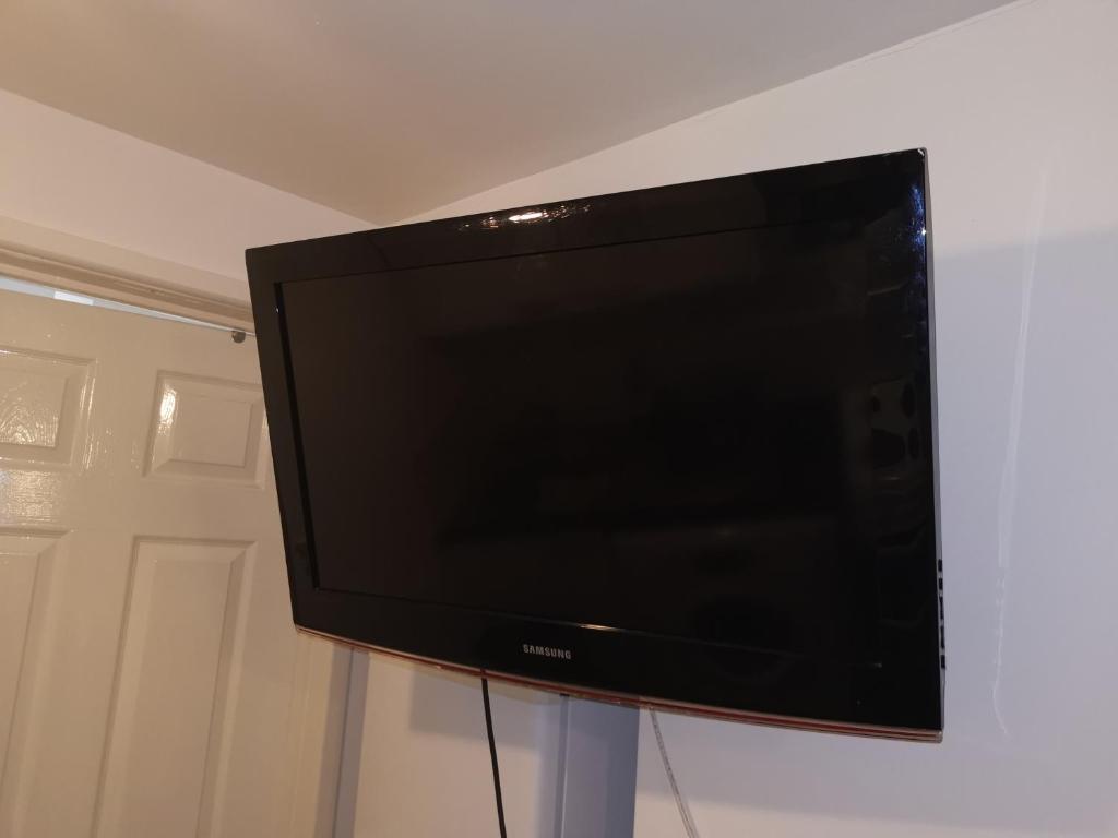 uma televisão de ecrã plano numa bancada num quarto em Argyll Studio Apartment - Luton Airport em Luton