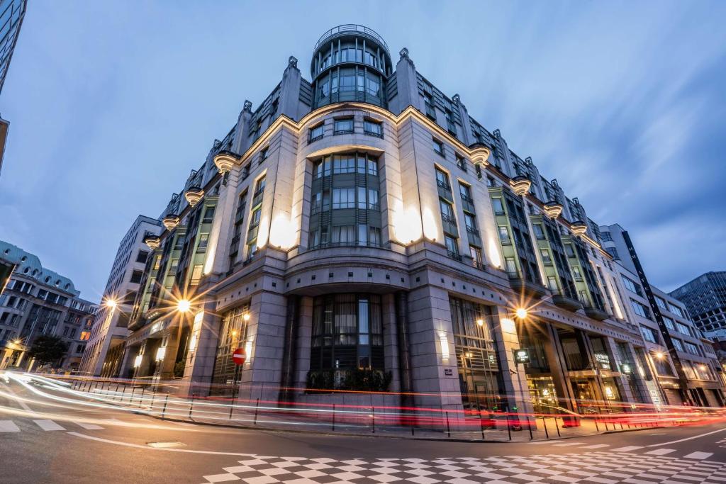 a large building on a city street at night at Radisson Collection Grand Place Brussels in Brussels