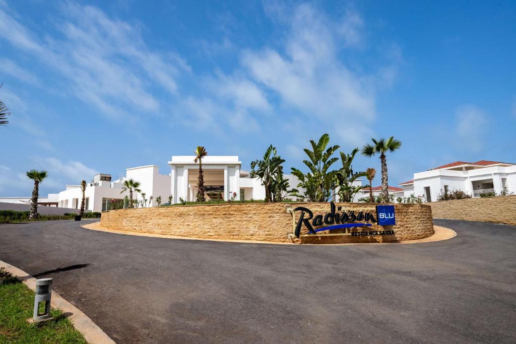 una carretera frente a una casa con palmeras en Radisson Blu Residences, Saidia, en Saidia 