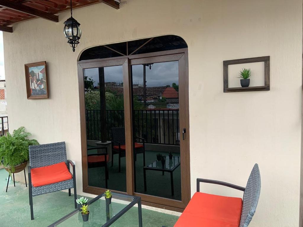 a patio with a sliding glass door with a table and chairs at El Mesón de los Abuelitos in Retalhuleu