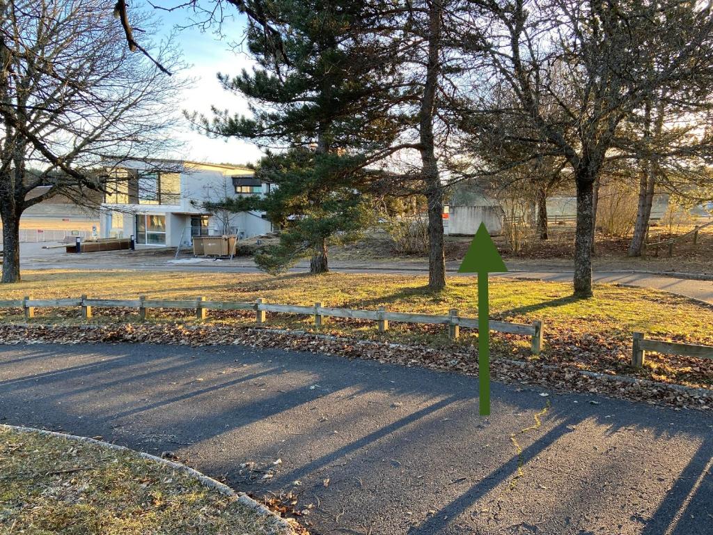 a road with a green arrow pointing to a house at Domaine de Mende Brenoux Suites & SPA in Mende