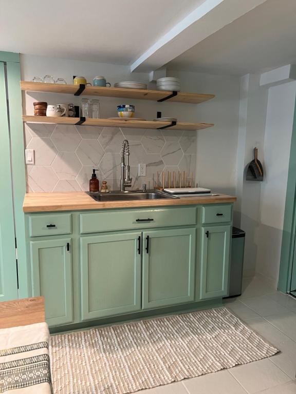 a kitchen with green cabinets and a sink at Sugar Sweet Home in Asheville