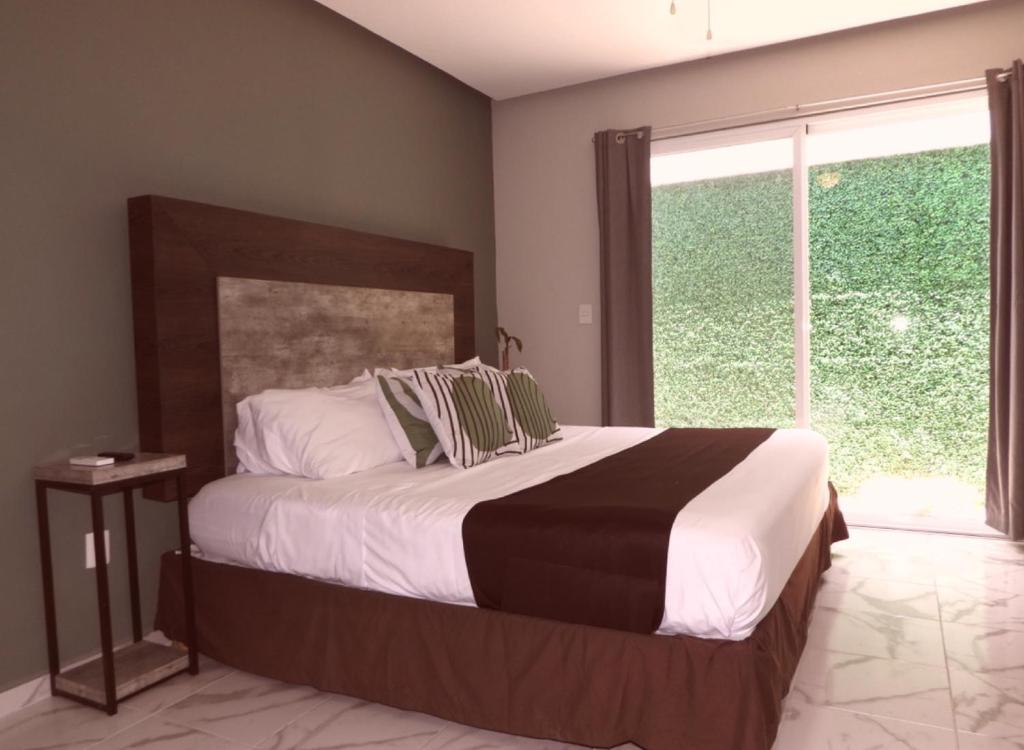 a bedroom with a large bed and a large window at Green Lofts in Cancún