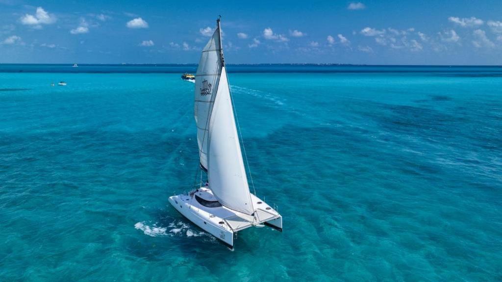 um veleiro branco na água no oceano em Casa nova 7 PRIVATE BATHROOM AND ROOM 2 BEDS em Cancún