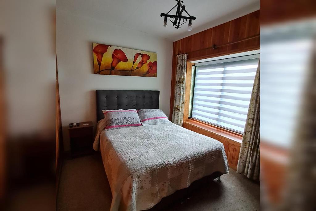 a small bedroom with a bed and a window at Habitación con baño privado A in Villarrica