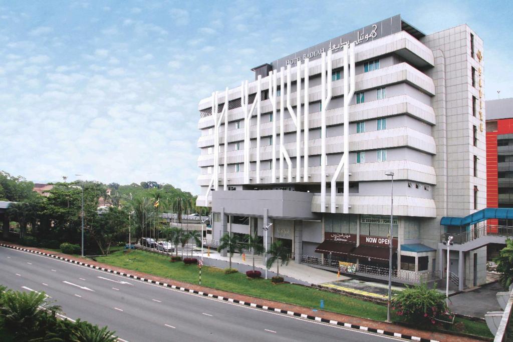 a large white building next to a road at Badi'ah Hotel in Bandar Seri Begawan