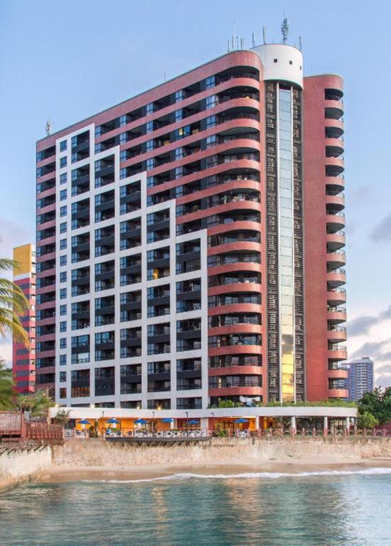 a large building on the beach next to the water at Flat Iate in Fortaleza