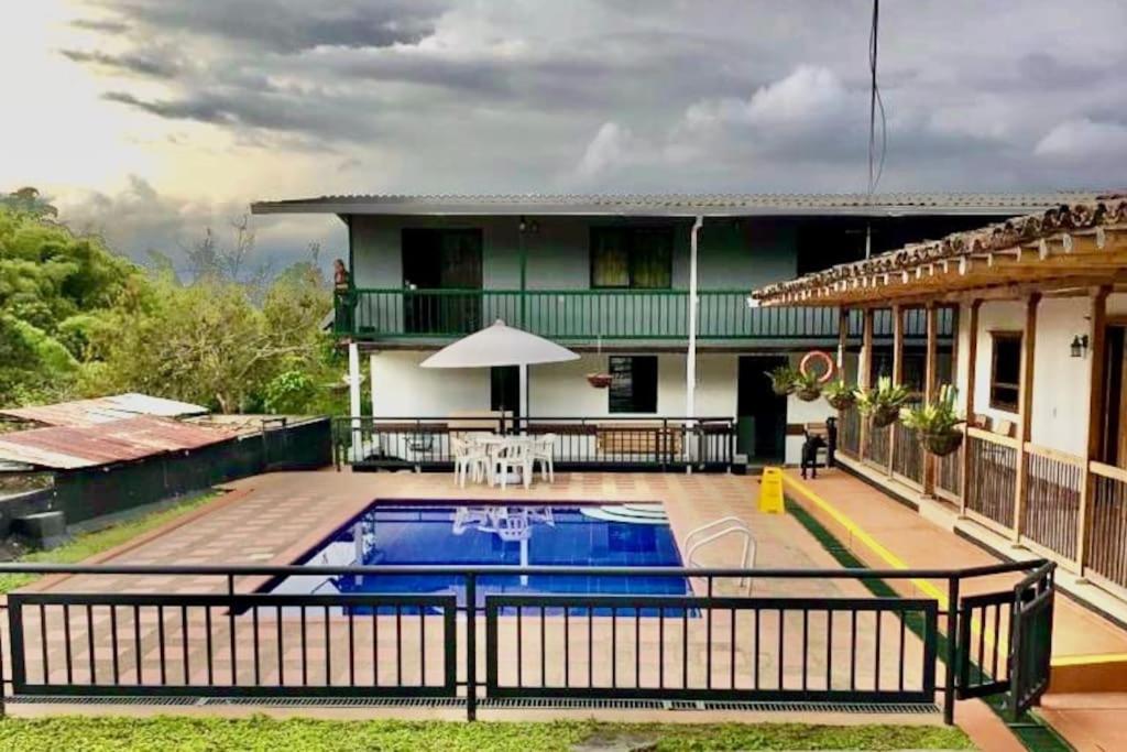 una casa con piscina frente a un edificio en Alojamiento Rural - La Perla, en Filandia