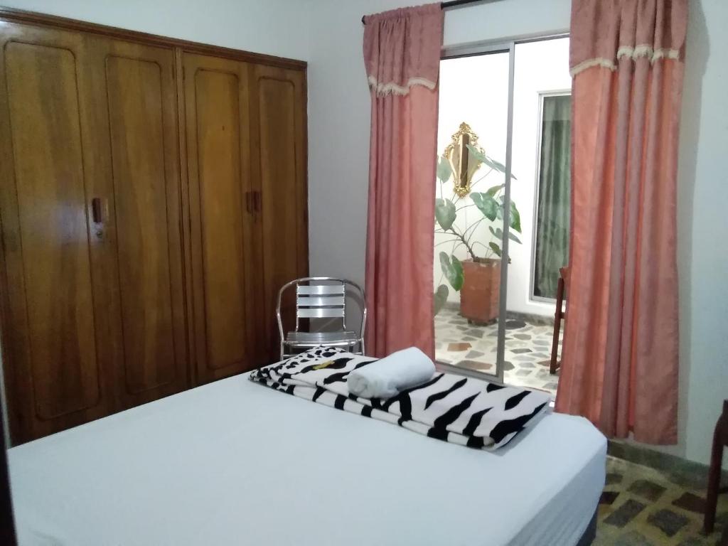 um quarto com uma cama e uma janela em CERCA AL AEROPUERTO CONTRALORIA AL LADO HOTEL TORREON No ES DOS QUEBRADAS MEDIA CUADRA ESTACION UCUMARI 30 AGOSTO em Pereira
