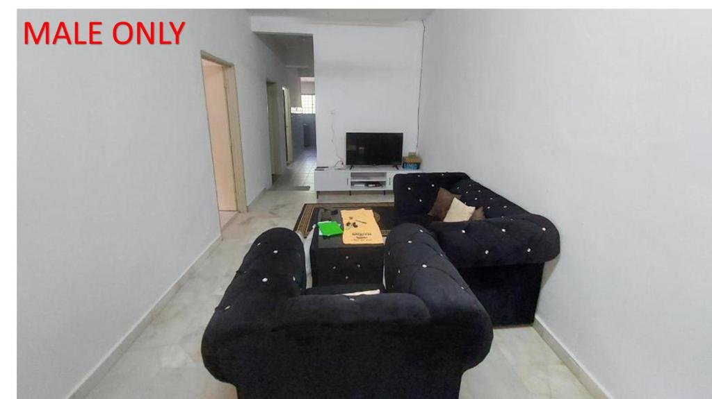 a black couch in a living room with a table at Roomstay Fiq in Kulim