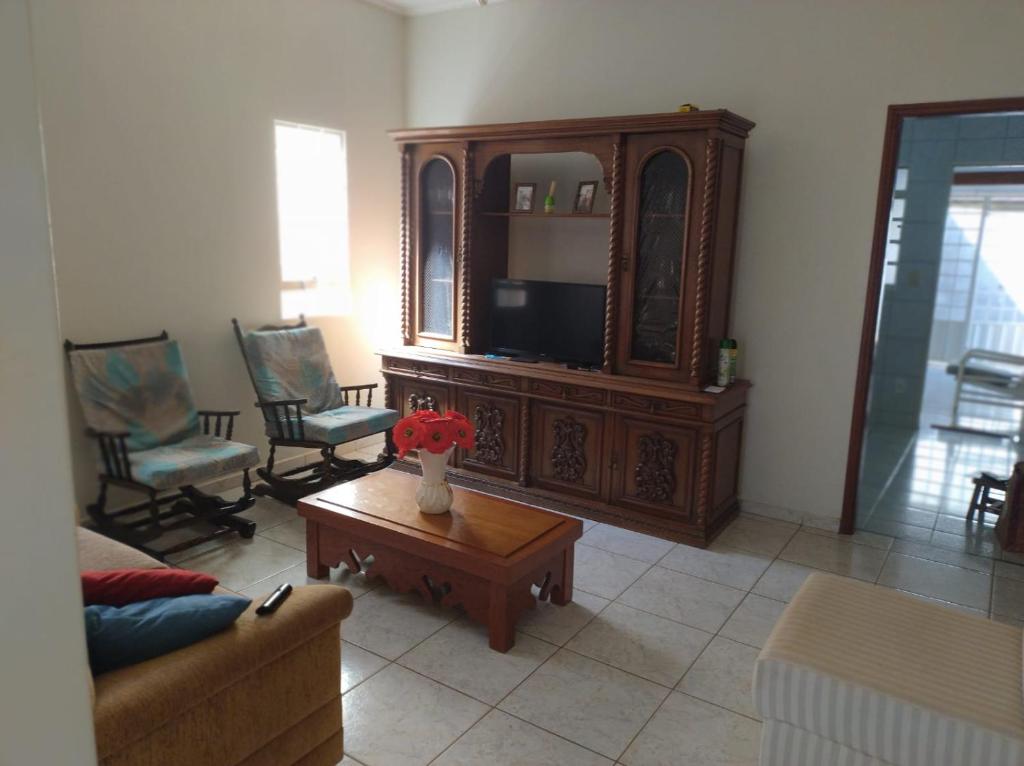 uma sala de estar com um sofá e uma televisão em Casa da Cidóca em Olímpia