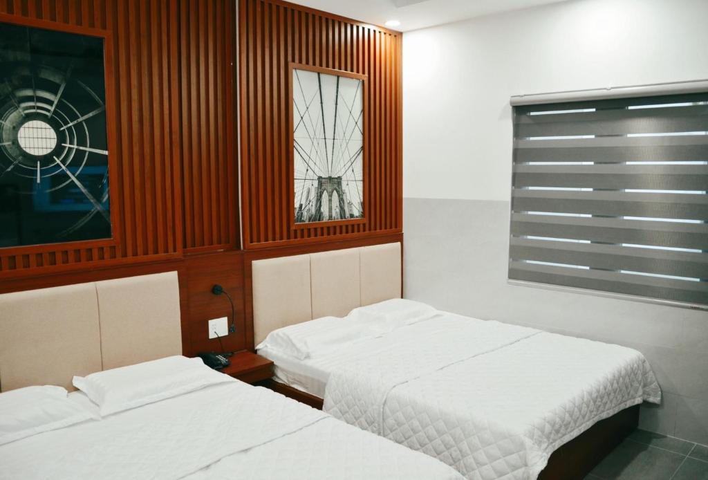 - une chambre avec 2 lits et une fenêtre dans l'établissement Tulip Hotel, à Hô-Chi-Minh-Ville