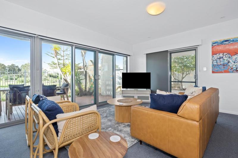 a living room with a couch and a television at Beachside Bliss 1 Bedroom Park View Villa in Mandurah