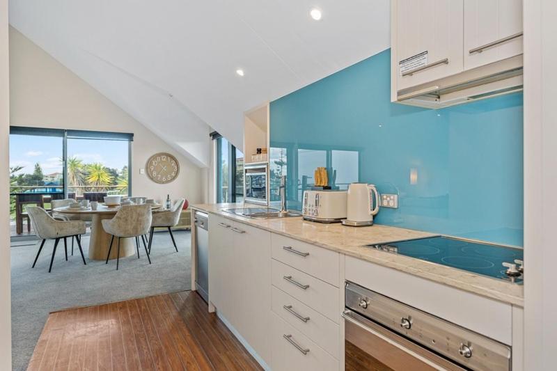 a kitchen with a counter and a dining room at Beachside Bliss 2 Bedroom Family Villa in Mandurah