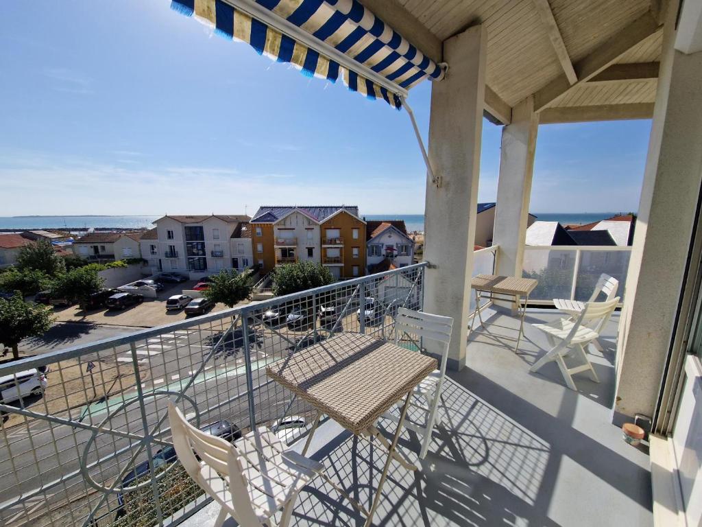 - un balcon avec un banc et des chaises dans un bâtiment dans l'établissement Duplex 3 pièces à deux pas de la plage avec parking - 4 pers - FR-1-706-16, à Châtelaillon-Plage