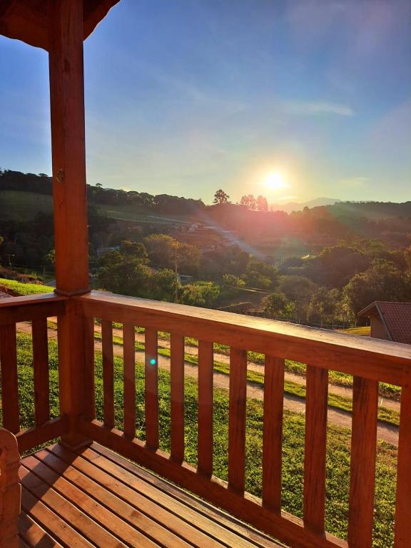 a view of the sunset from the porch of a cabin at Chalés Roma in Santo Antônio do Pinhal