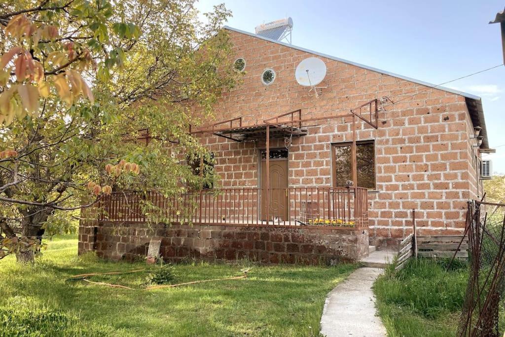 a brick house with a porch and a door at Собственный дом в фруктовом саду 