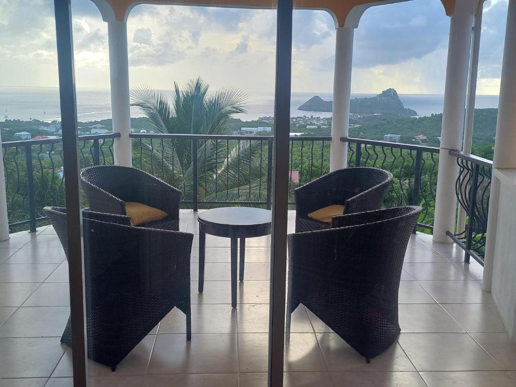 d'un balcon avec des chaises et une table offrant une vue sur l'océan. dans l'établissement Bellevue hideaway, à Gros Islet