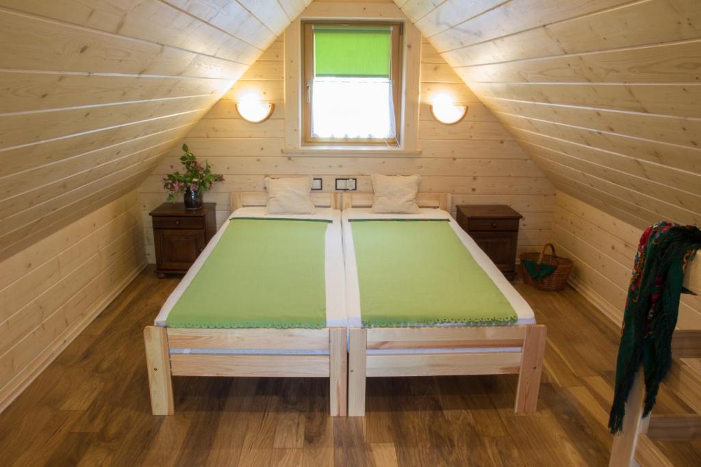 1 dormitorio con 1 cama en un ático de madera en Domek góralski u Felusia en Szczawnica
