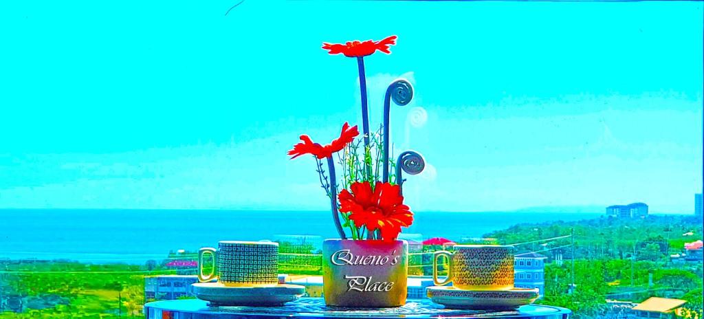 a vase with red flowers in it on a table at Mactan Newtown - New Modern Condo with Ocean View in Mactan