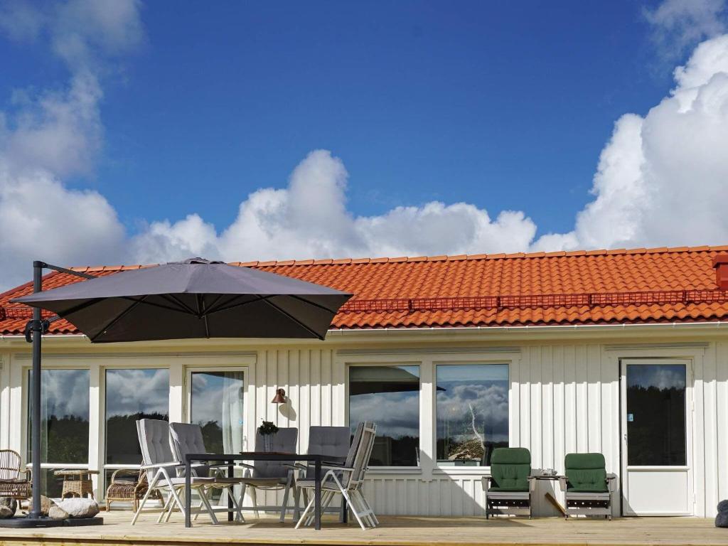 une terrasse avec une table, des chaises et un parasol dans l'établissement Holiday home Grebbestad XII, à Grebbestad