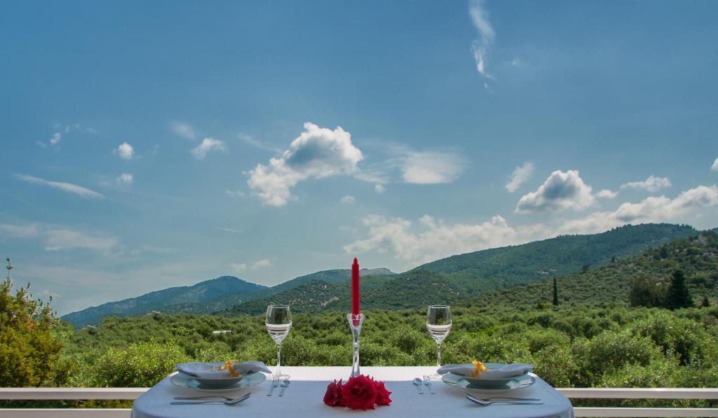 - une table avec des verres à vin et une vue sur les montagnes dans l'établissement Second Home, à Skala Sotiros