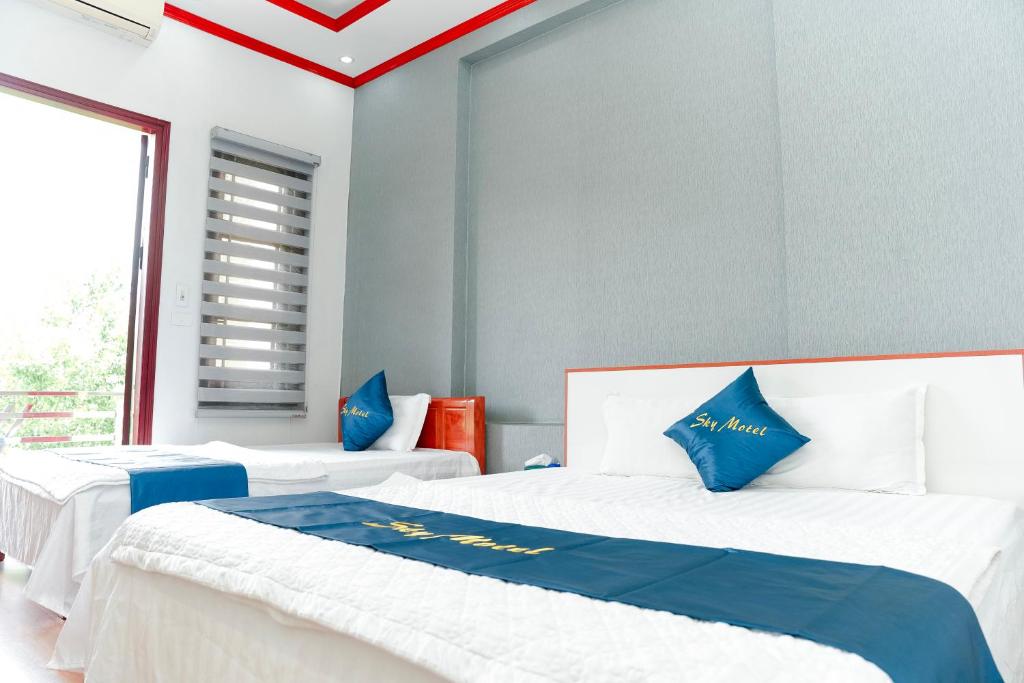2 letti in una camera con blu e bianco di SKY HOTEL - KHÁCH SẠN BẮC NINH a Bồ Sơn