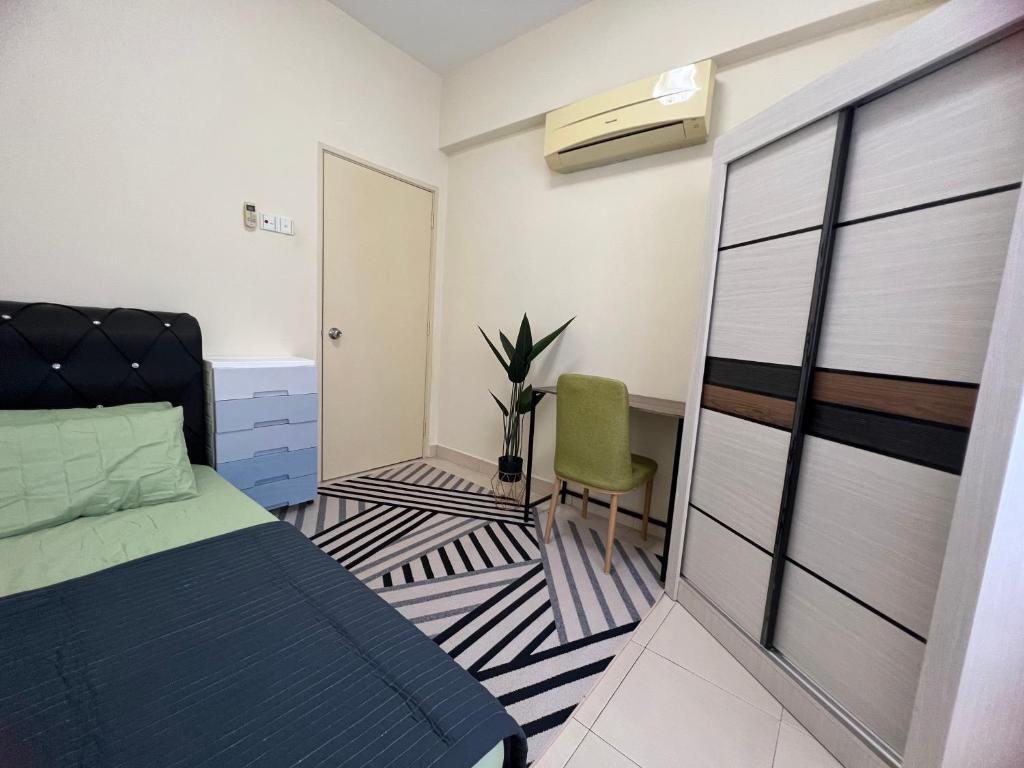 a bedroom with a bed and a chair in it at JR GUESTHOUSE in Ampang
