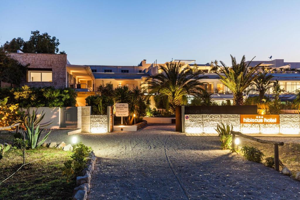 a building with a sign in the middle of a driveway at Hotel Residence Hibiscus in La Caletta