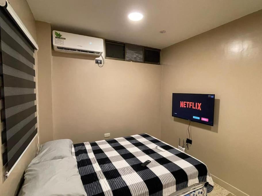 een kamer met een bed en een tv aan de muur bij Hermosa suite acogedora y hermosa, Las Garzas 2 in Guayaquil