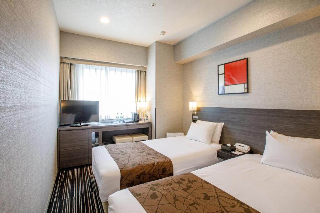 Un pat sau paturi într-o cameră la Hotel Sunroute Fukuchiyama