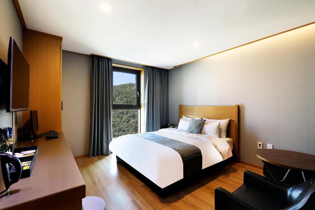 una camera d'albergo con letto e finestra di Paju Golden Hill a Paju