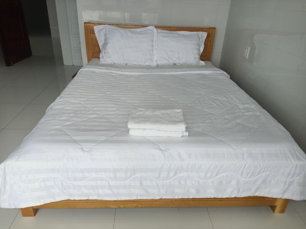 a bed with white sheets and towels on it at HOTEL VTV DỐC LẾT in Ninh Hòa