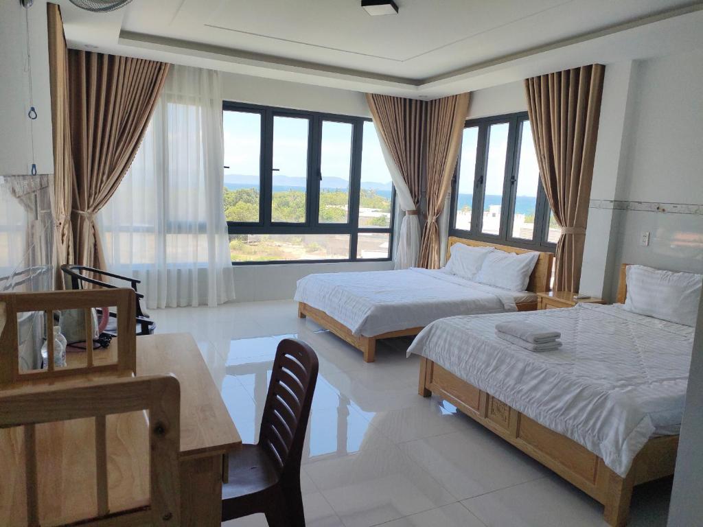 a bedroom with two beds and a table and chairs at HOTEL VTV DỐC LẾT in Ninh Hòa