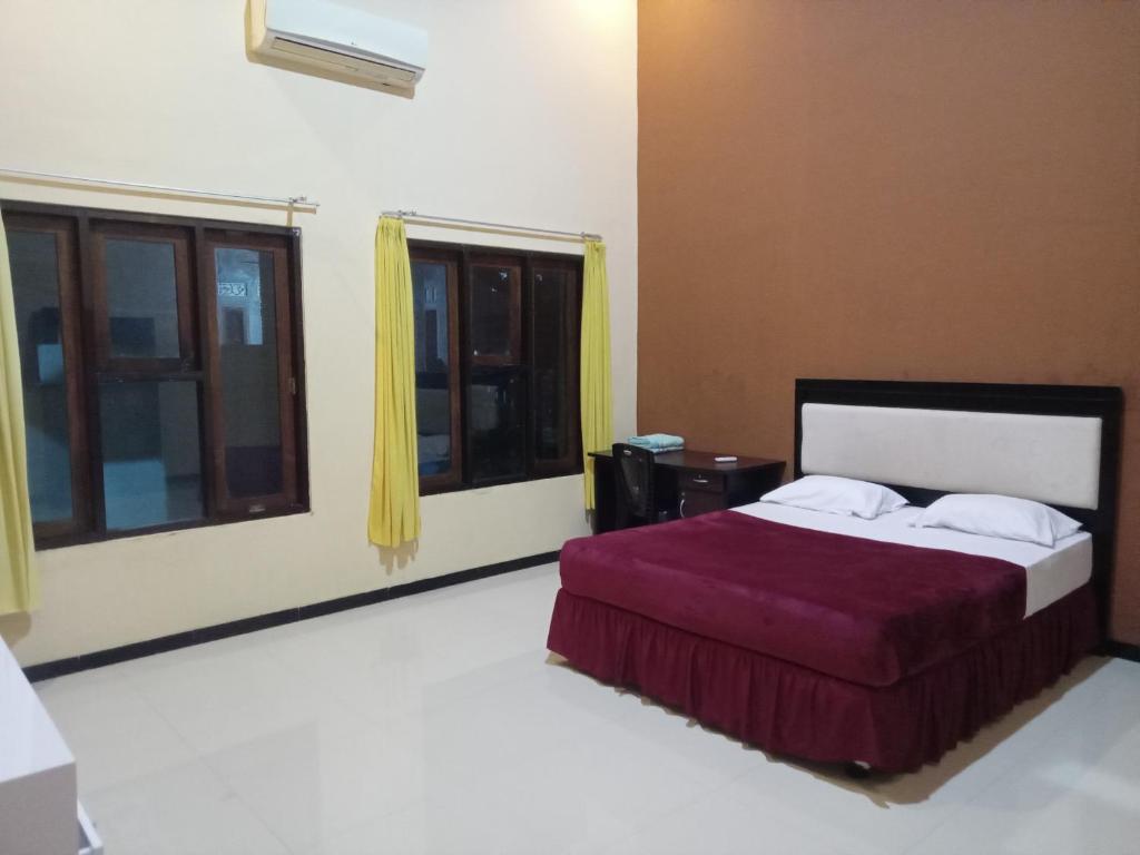 1 dormitorio con 1 cama y 2 ventanas en Ijen Transito 2 homestay, en Ketapang