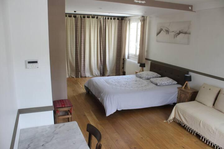 ein Schlafzimmer mit einem Bett, einem Sofa und einem Tisch in der Unterkunft chambre avec entrée indépendante in Saint-Priest