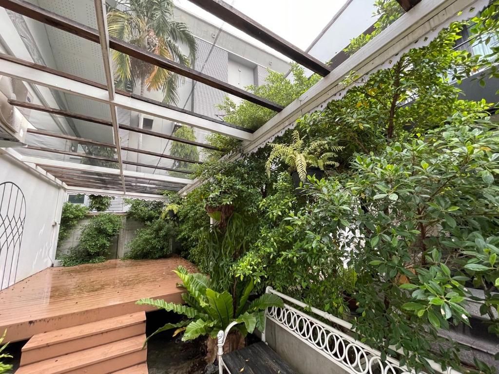 home near MRT Tha Phra Villa sookkasem في Bangkok Yai: منزل زجاجي به بلكونه تحتوي على نباتات