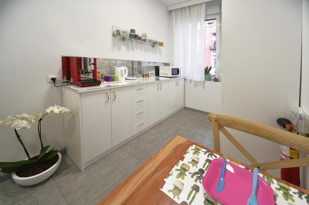 una cucina con armadi bianchi e un tavolo in una stanza di konak rooms l Skanderbeg Square a Tirana