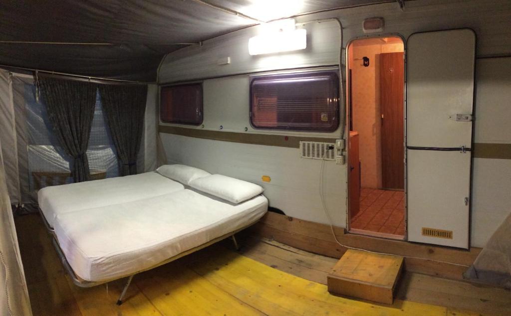 una piccola camera con un letto e una porta di Campeggio Ricortola Mare a Marina di Massa