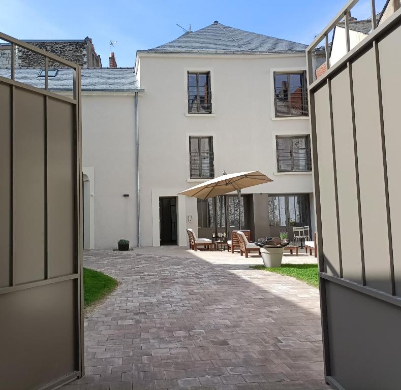una porta aperta su un edificio bianco con patio di Villa Buffon ad Angers