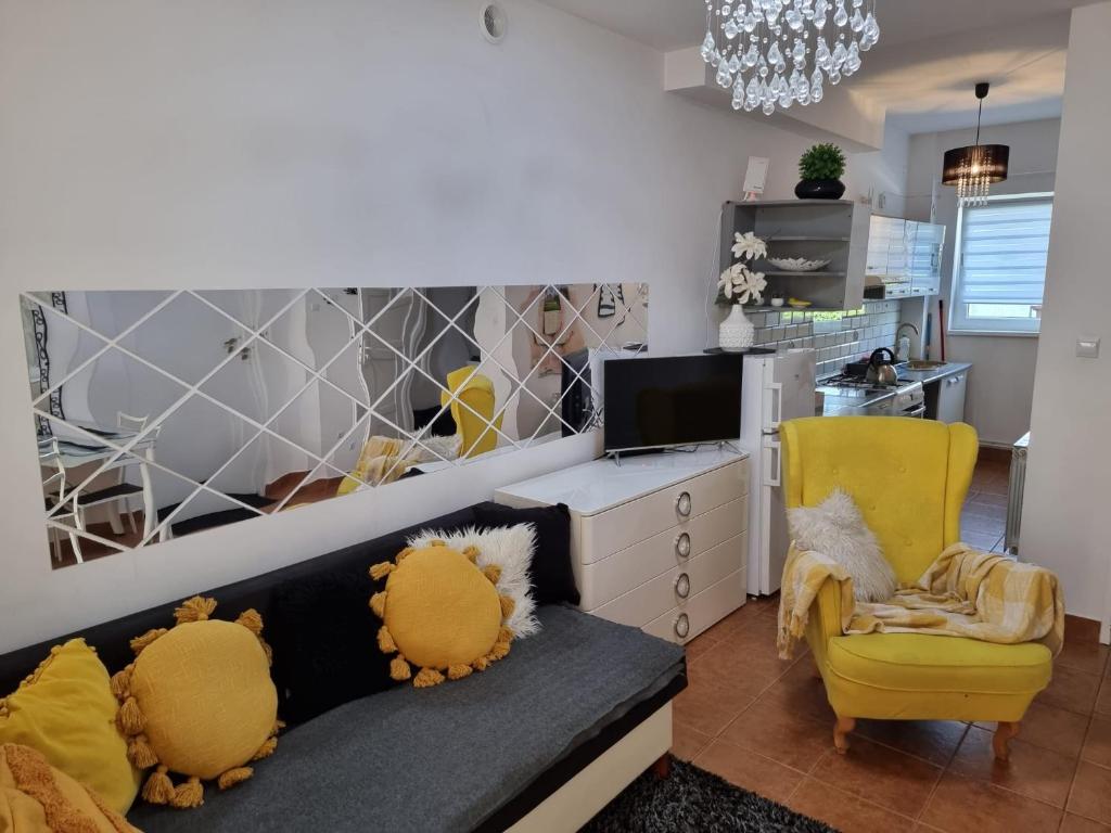 a living room with a couch and a yellow chair at Apartamenty Tomaszów Lubelski - Żółty in Tomaszów Lubelski